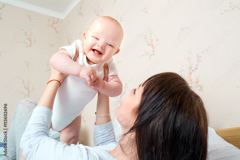 Mom raised her hands up baby, baby smiling and laughing. A happy Mom raised her hands up baby, baby smiling and laughing. A happy