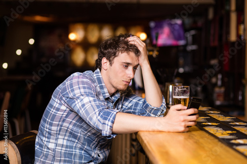 single man sitting at bar having a beer photo
