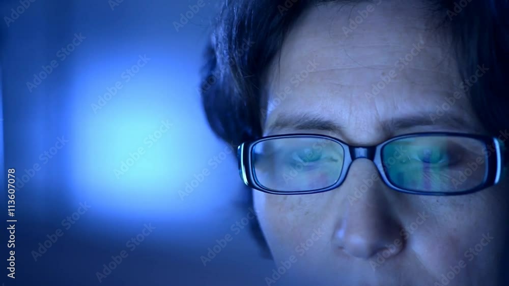 Closeup on one eye of a woman wearing glasses and looking at a computer screen. Closeup on one eye of a woman wearing glasses and looking at a computer screen.