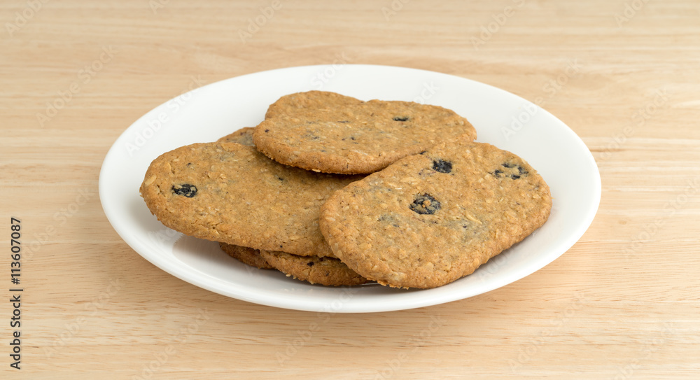 Blueberry wafer cookies on a white plate atop a wood table side view. Blueberry wafer cookies on a white plate atop a wood table side view.