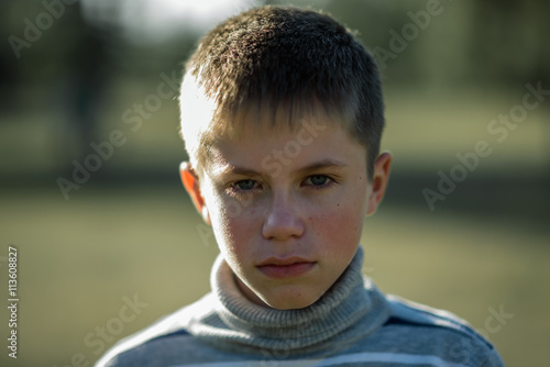portrait unhappy teenage boy lit by the sun © alexx_60
