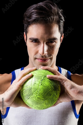 Portrait of happy athlete man holding ball 