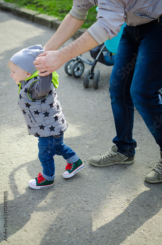 Father guiding his baby with the first steps