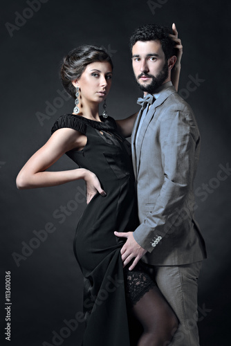 Beautiful lady in dress with guy in suit. Young couple is hugging each other. Portrait of girl with attractive body and boy indoors in passionate pose. Beauty woman with lace gown