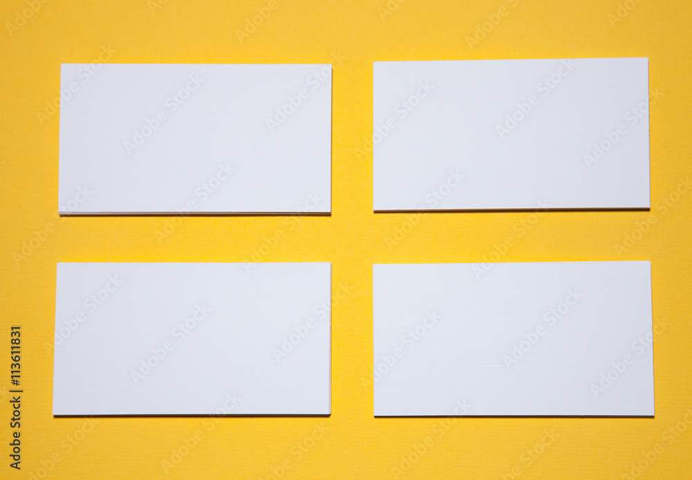 Empty business cards on yellow background - closeup shot Empty business cards on yellow background - closeup shot