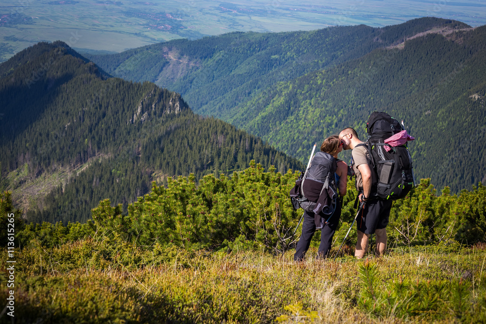 Young couple in the Carpathian mountains while kissing.