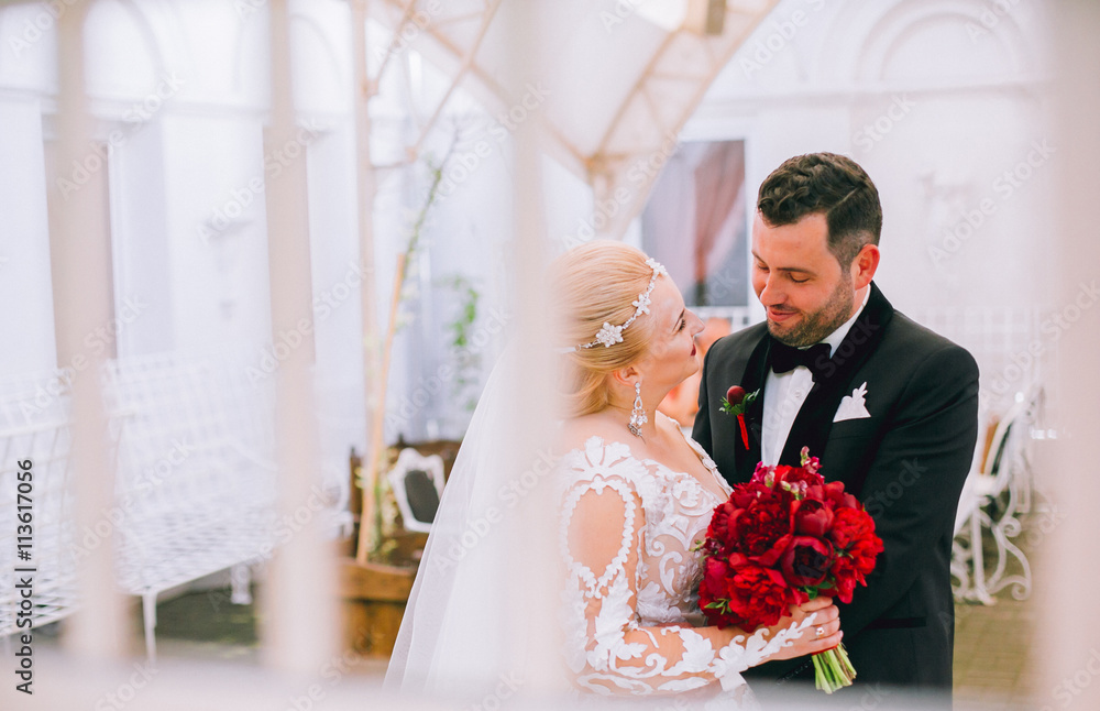 bride and groom embracing and talnking on the summer terrace at the restaurant