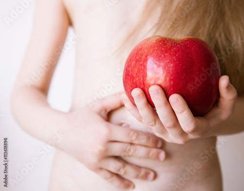 Unrecognizable little girl holding a red apple