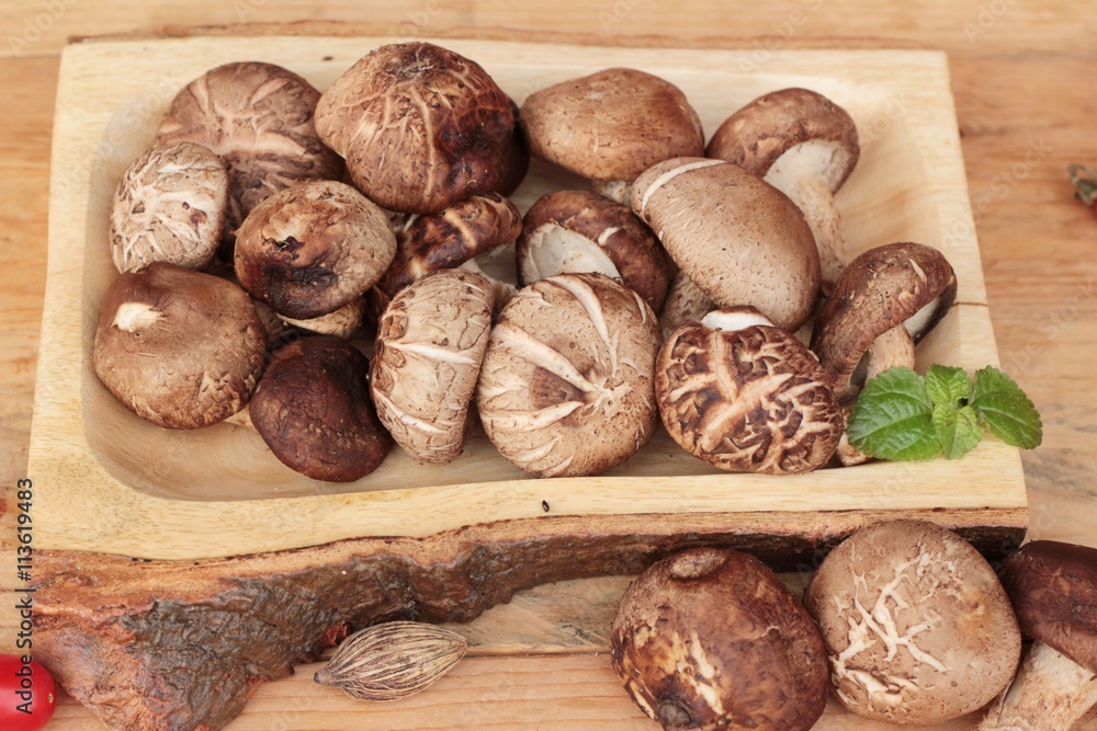Fototapeta premium Shiitake mushrooms for cooking on wood background.