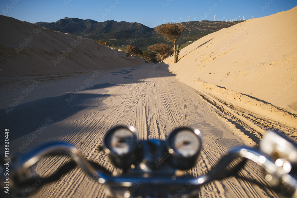 Spain, Andalusia, Tarifa, Punta Paloma, Moto on a road between dunes,  covered with sand Stock Photo | Adobe Stock