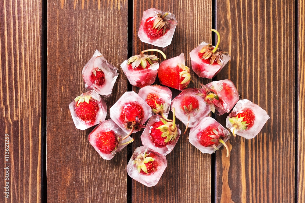 fresh strawberries in ice on a wooden background