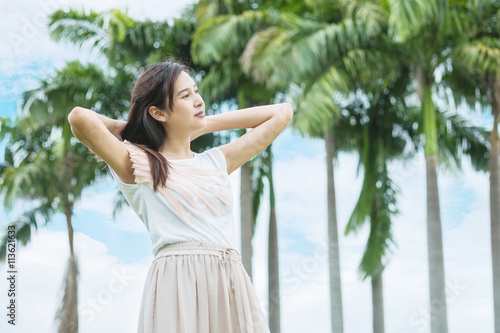 Asian woman stand in the garden with freshness emotion in the morning with blue sky and cloud