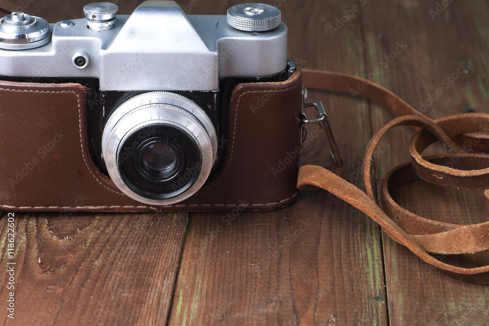 Old retro camera on vintage wooden boards abstract background. Copy space for text