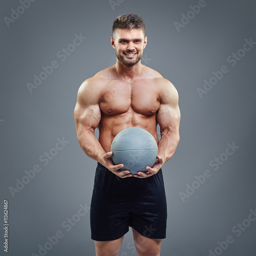 Muscular man holding a medicine fitness ball