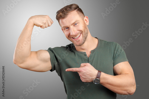 smiling man showing biceps