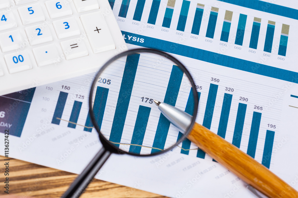 Obraz premium Calculator and magnifying glass on the table