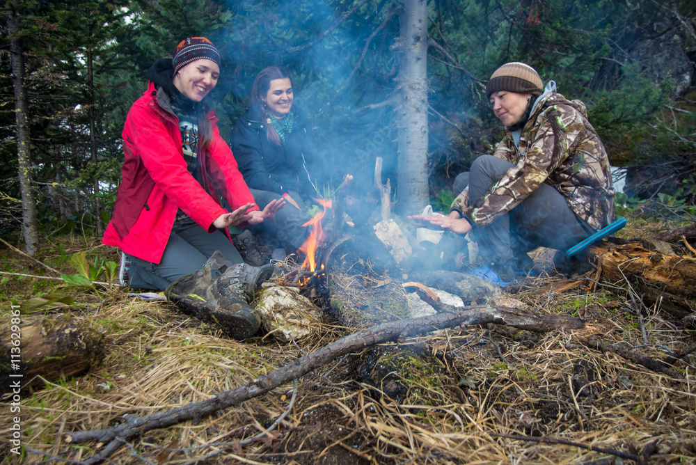 girls sit around the campfire