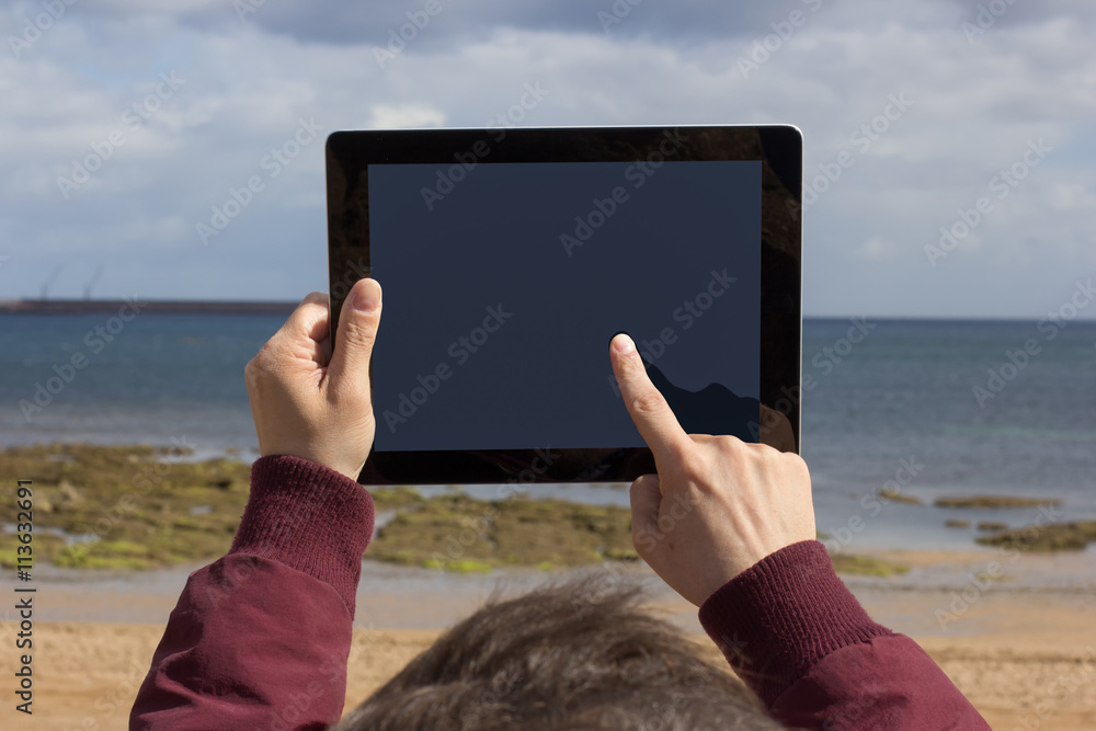 Man using tablet with on the beach