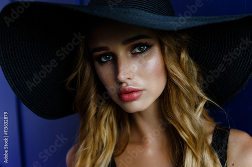 Holidays and summer fashion. Woman in big black hat. Portrait of charming female