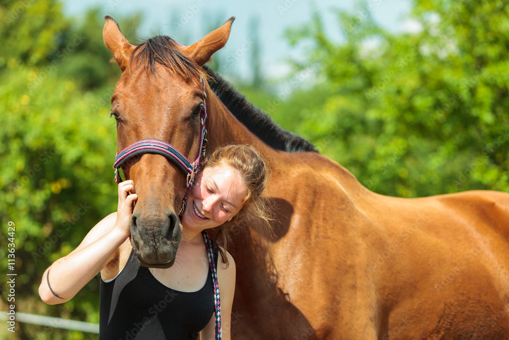 Obraz premium Young woman girl taking care of horse.