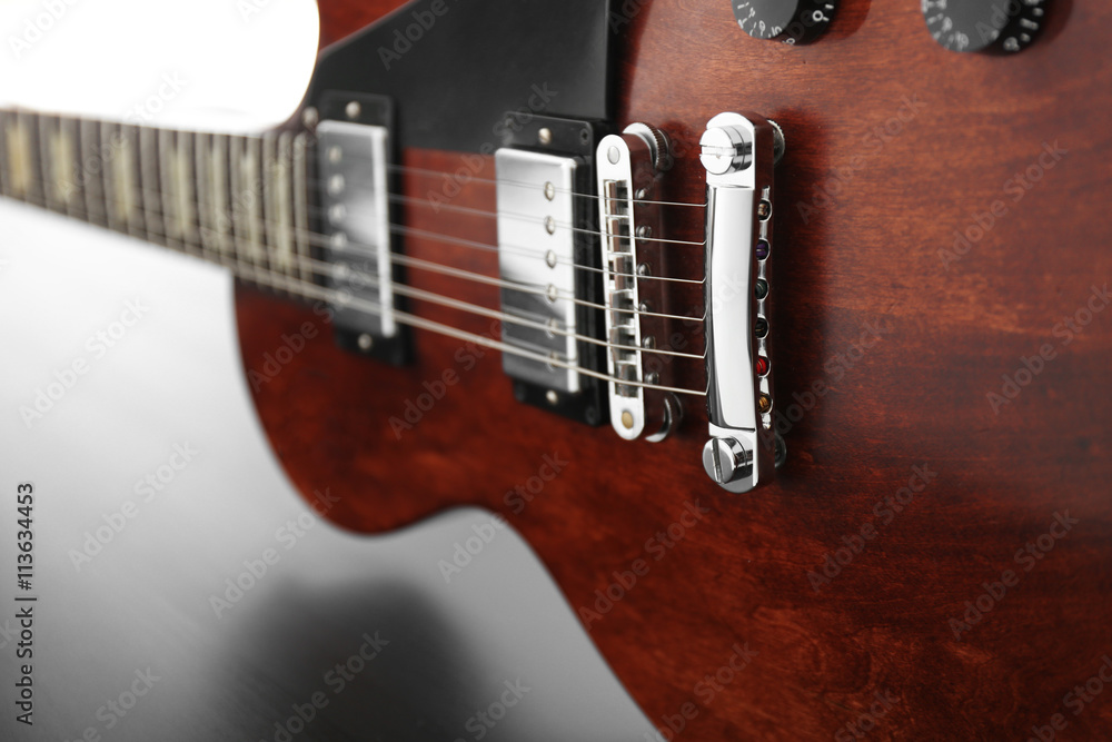 Obraz premium Brown electric guitar on black wooden background, close up