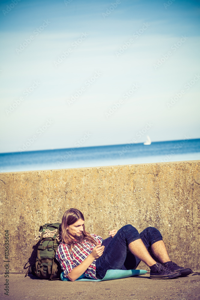 Man tourist backpacker sitting with tablet outdoor Man tourist backpacker sitting with tablet outdoor