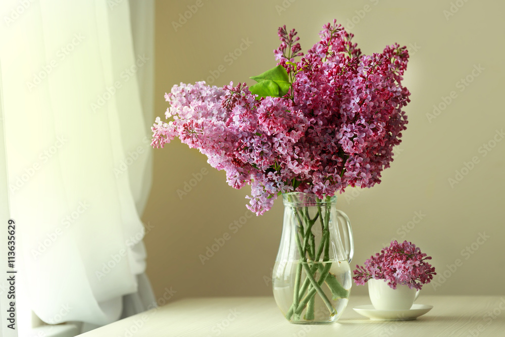 Bouquet of purple lilac flowers on white wooden table