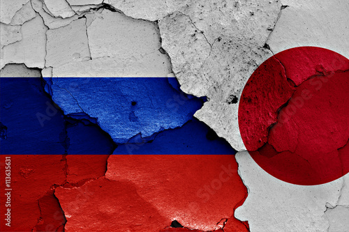 flags of Russia and Japan painted on cracked wall
