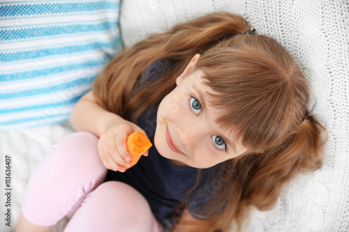 Little girl with carrot sit...