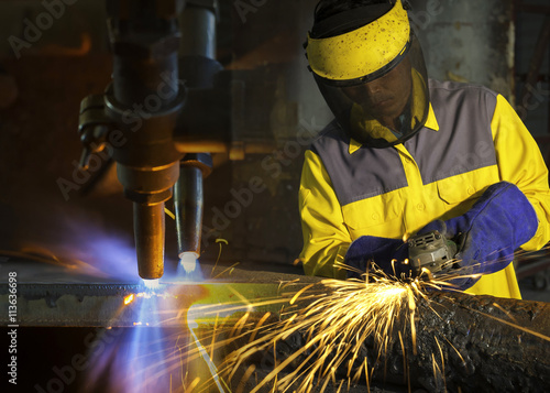 Metal cutting with acetylene torch and grinding worker
