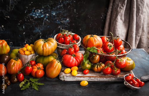 Colorful tomatoes on dark marble table, 