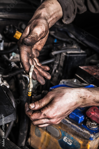 Dirty man hands and car engine