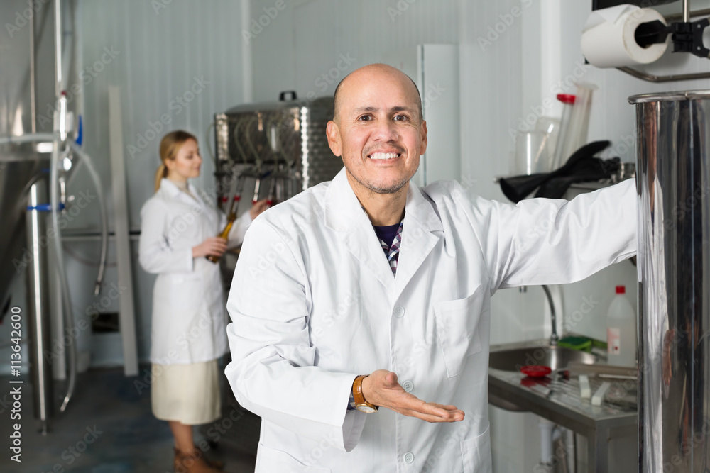Obraz premium Mature man among brewery equipment