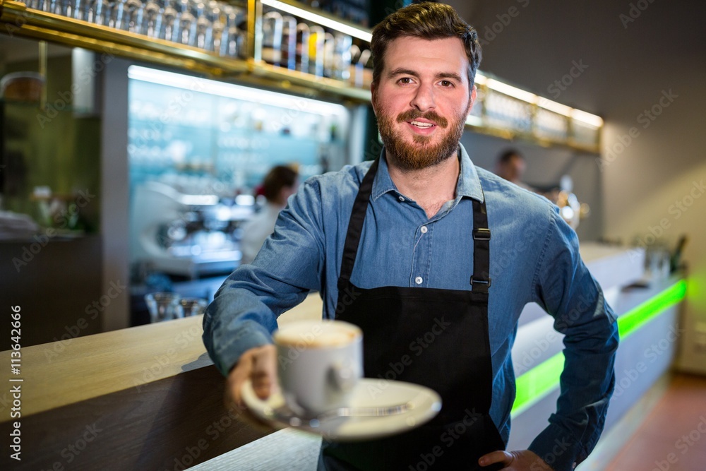 Waiter offering cup of coffee