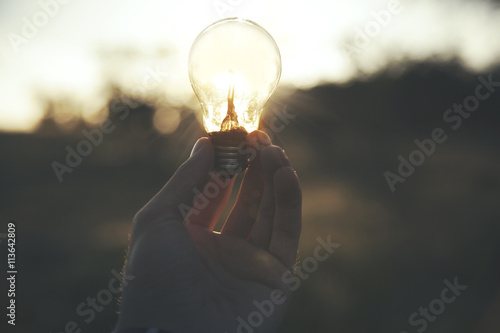 man hand bulb in nature photo