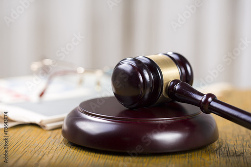 Labor law concept, gavel, glasses and newspaper on wooden table photo