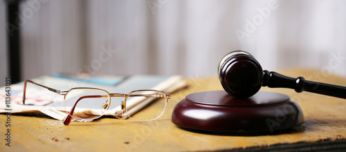 Labor law concept, gavel, glasses and newspaper on wooden table photo