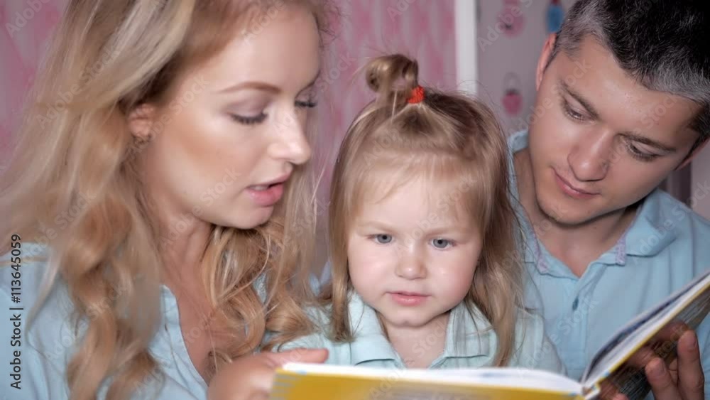 Young parents read the book to children at home. Mother Father and Daughter reading. Young parents read the book to children at home. Mother Father and Daughter reading.