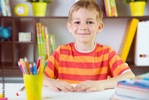  School boy at classroom desk making schoolwork