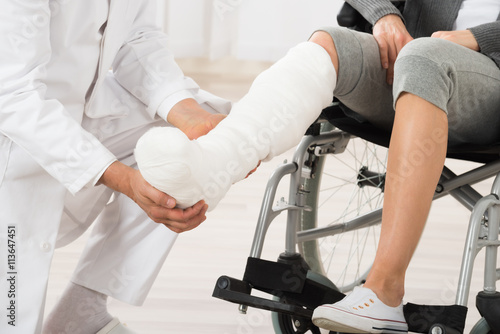 Fotografie Doctor Examining Leg Of Patient
