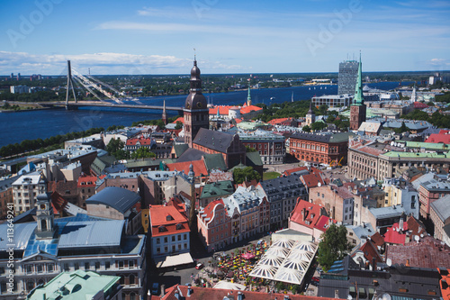 Beautiful super wide-angle panoramic aerial view of Riga, Latvia with harbor and skyline with scenery beyond the city, seen from the St. Peters Church observation tower, sunny summer day