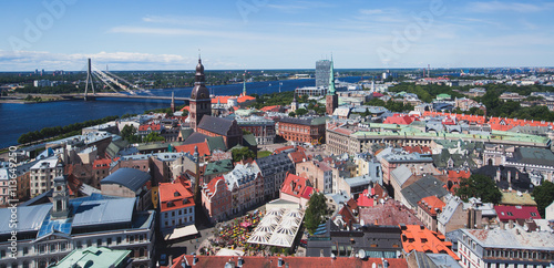 Beautiful super wide-angle panoramic aerial view of Riga, Latvia with harbor and skyline with scenery beyond the city, seen from the St. Peters Church observation tower, sunny summer day