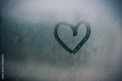 Картината върху платно Sign of love heart on glass. The window is fogged up background