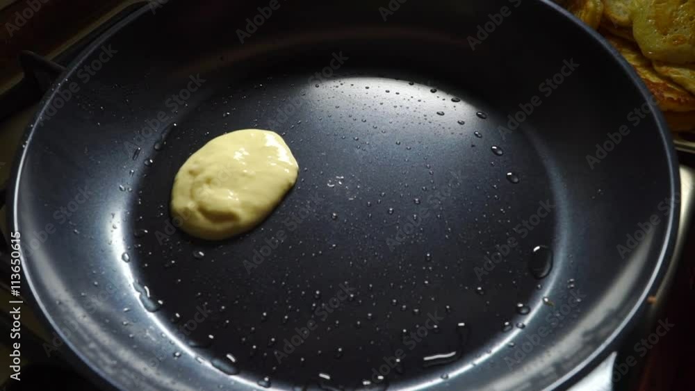 Putting pancake dough on a hot frying pan Putting pancake dough on a hot frying pan