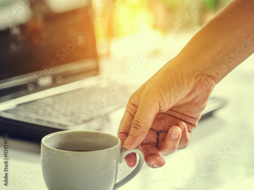 Coffee cup and laptop for business, Selective focus on coffee.