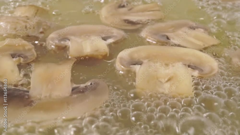 Sliced field mushrooms in boiling water, close up slow motion shot Sliced field mushrooms in boiling water, close up slow motion shot