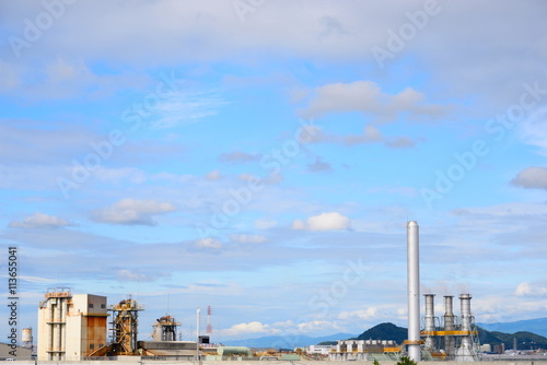 工業団地の煙突と白い雲 青空に架かる白い雲と工業団地の煙突の景色が印象的だった。