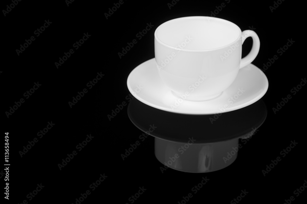 White cup on glossy black background White cup on glossy black background