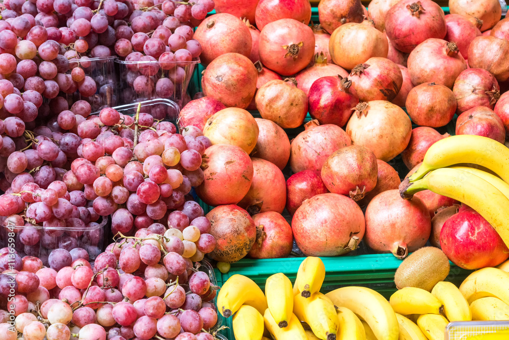 Grapes, bananas and pomegranate for sale at a market Grapes, bananas and pomegranate for sale at a market