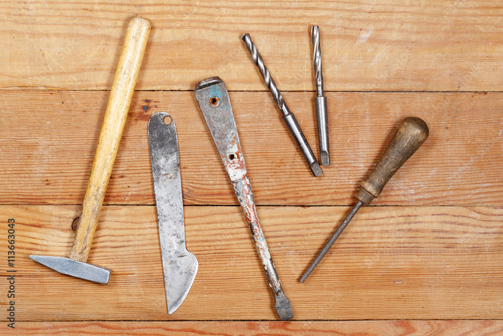 Old tools on wooden boards. Hammer, knife, screwdriver, file, drill. Old tools on wooden boards. Hammer, knife, screwdriver, file, drill.